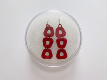 Load image into Gallery viewer, Trapezoid hook earrings in their case, made from red 3D printed nylon with sterling silver components